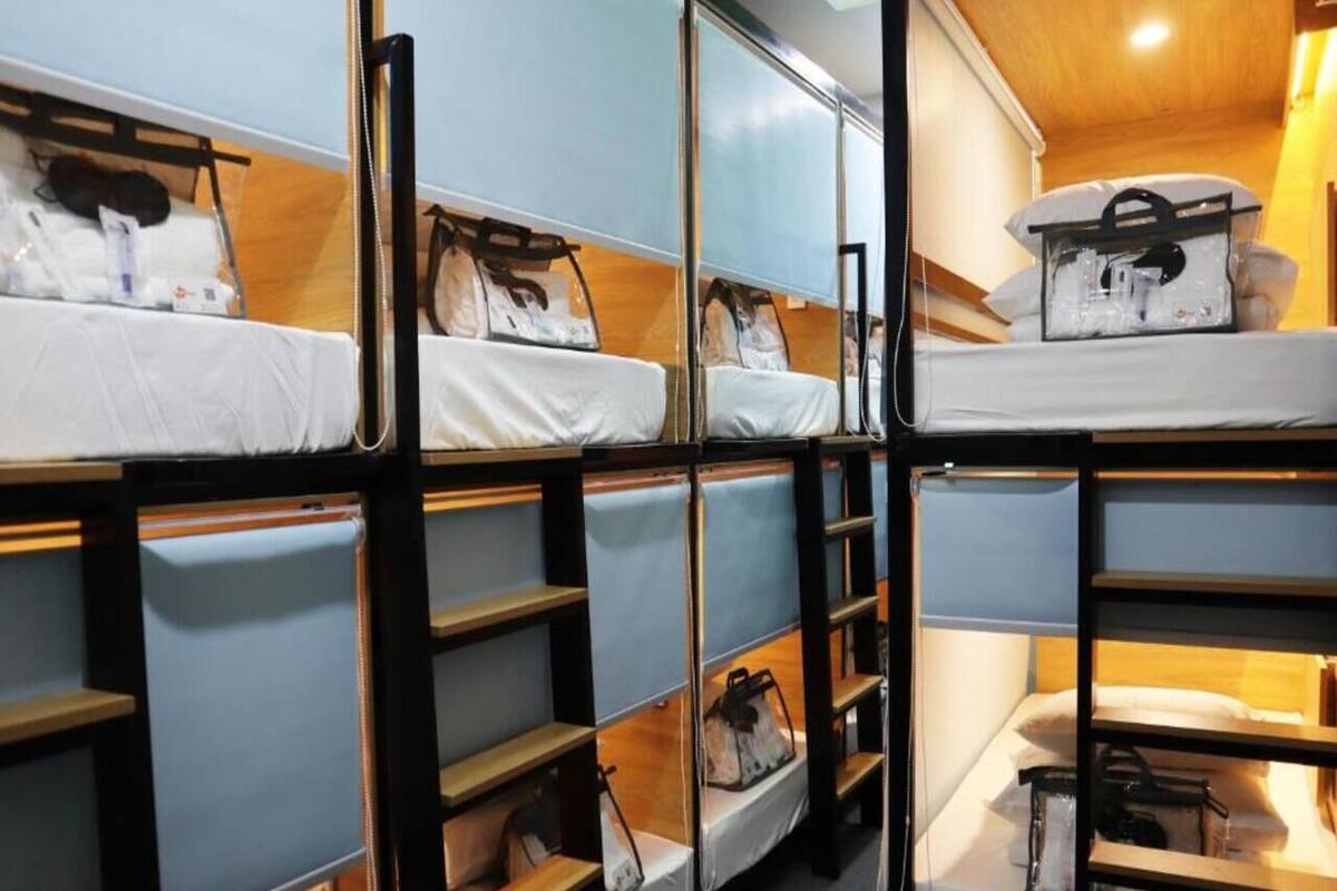 Bunk beds with storage compartments, a wooden floor, and a small table.
