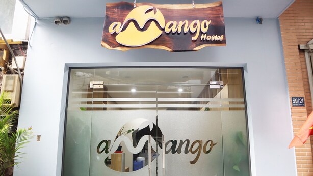 A hotel entrance with a glass door featuring the name 'ango' in stylized lettering. - Amango Hostel (Ho Chi Minh City)