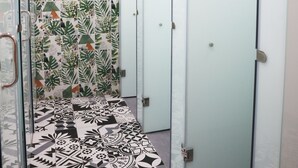 A hallway with patterned tiles, a glass door, and a tiled floor. - Amango Hostel (Ho Chi Minh City)