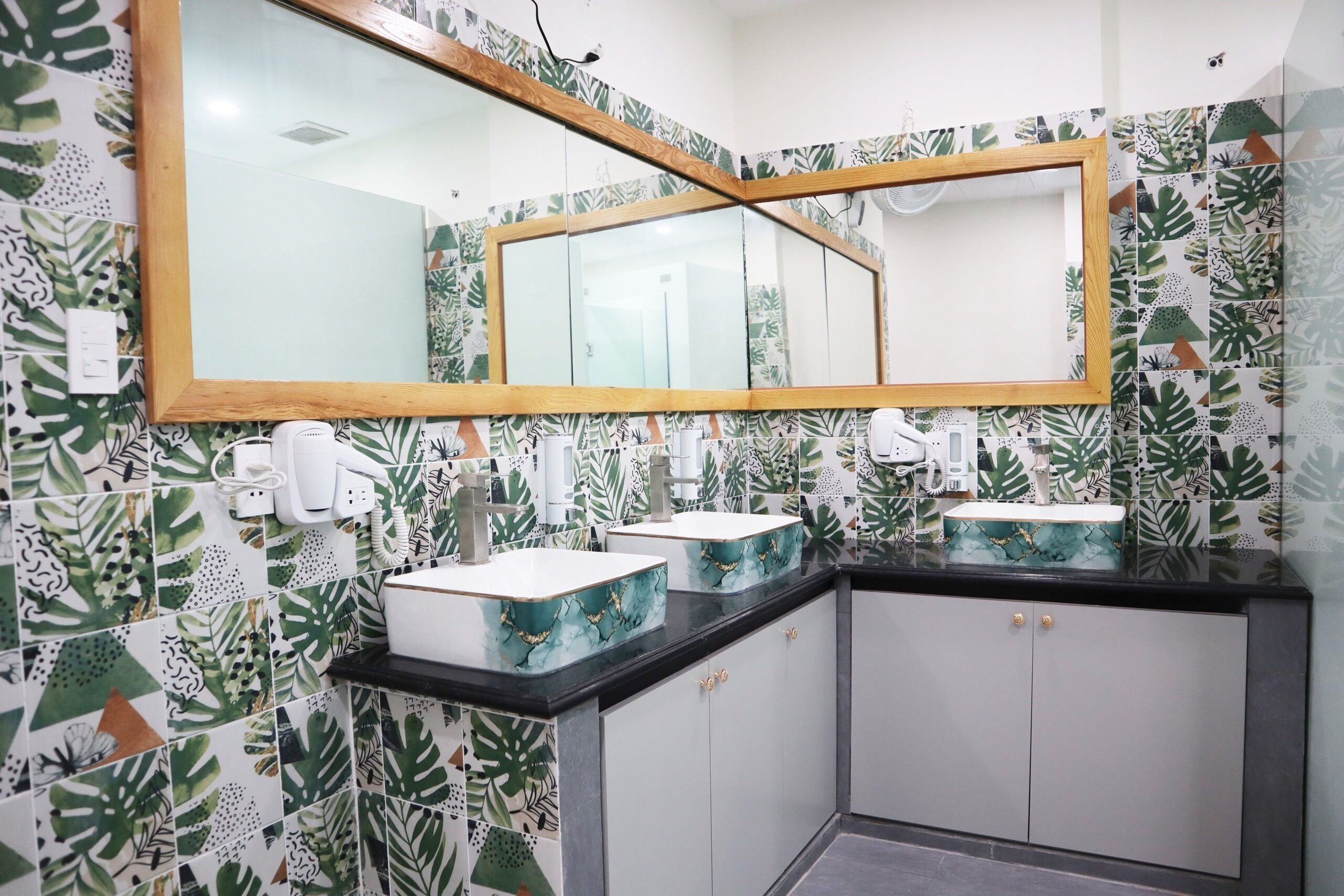 A bathroom with two sinks, a large mirror, and a cabinet.