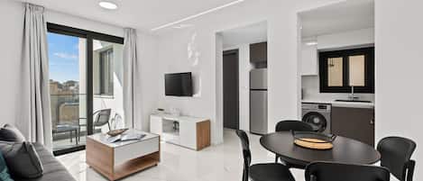 A modern apartment with a dining area, kitchen, and living space.