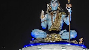 Una statua di una divinità con un tridente, seduta su una piattaforma con una testa di leone alla base.