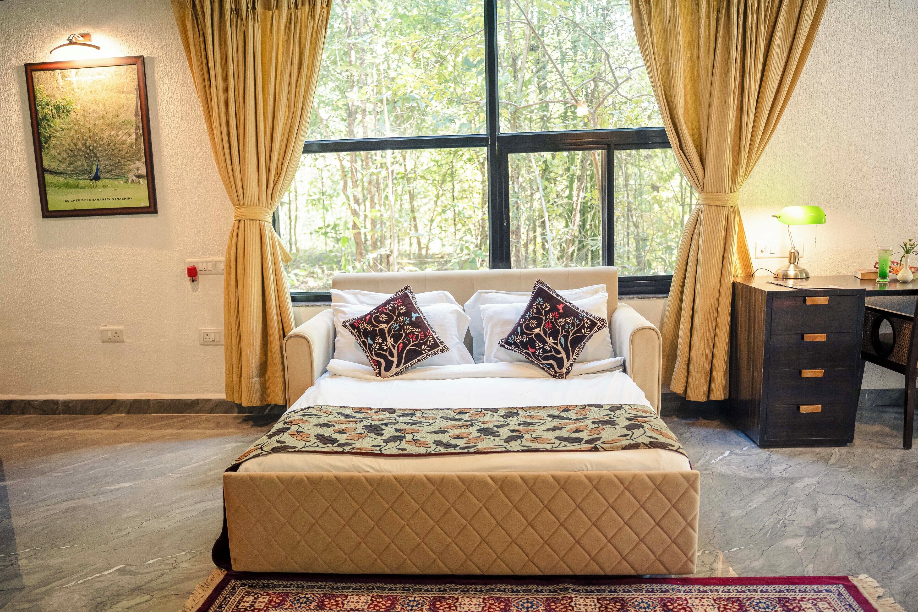 A neatly arranged bedroom with a bed, a desk, and a window with curtains.