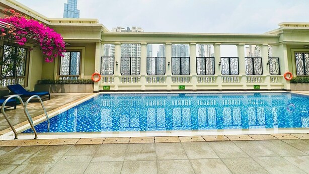 Una piscina con vistas despejadas a edificios altos al fondo.