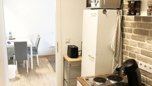 A compact kitchen with a refrigerator, microwave, toaster, coffee maker, and a small countertop with a kettle. - Birkenhof Family Lodge  (Rieschweiler-Mühlbach)