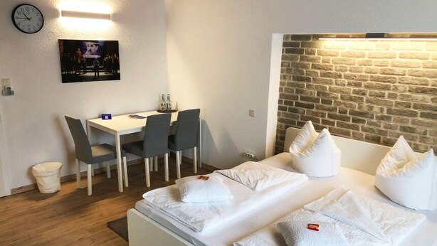 A hotel room with a bed, a desk, and chairs. - Birkenhof Family Lodge  (Rieschweiler-Mühlbach)