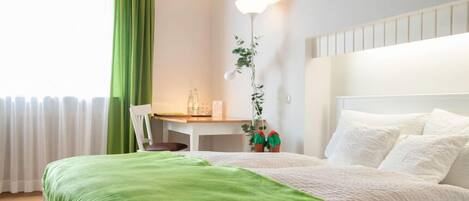 Una habitación de hotel ordenada con cama, escritorio y silla.