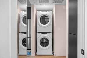 A laundry room with two stacked Whirlpool washers and dryers. - King Bed, EV Charger, Sleeps 8, Balcony, Laundry (San Diego)