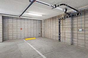 A parking garage with concrete floors, tiled walls, and visible plumbing. - King Bed, EV Charger, Sleeps 8, Balcony, Laundry (San Diego)
