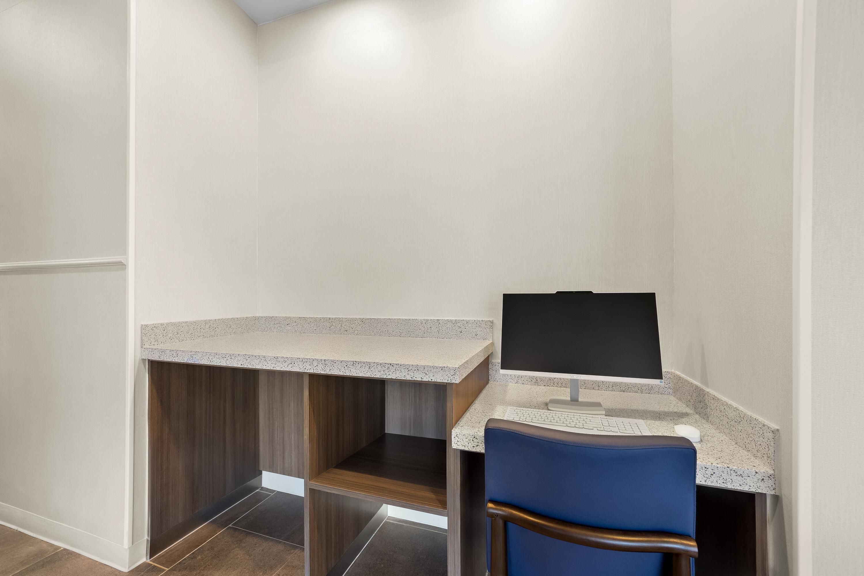 A small workspace with a desk, chair, and computer monitor.