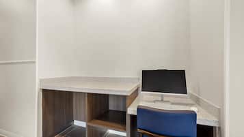 A small workspace with a desk, chair, and computer monitor.
