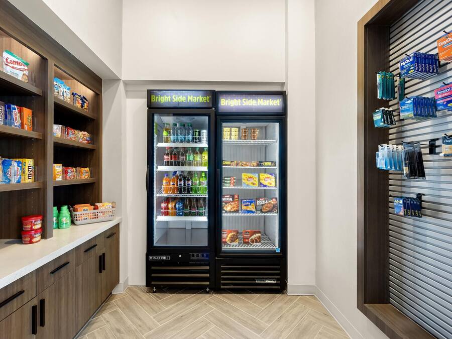 A vending machine stocked with snacks and drinks, adjacent to a shelf with packaged goods.