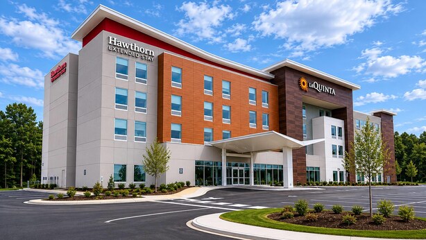 Un hotel moderno con techo plano, ventanas amplias y entrada cubierta.