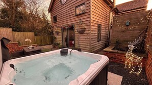 A wooden house with a hot tub in the backyard. - Stone Cottage Norfolk , Lovely Family Cottage (Norwich)