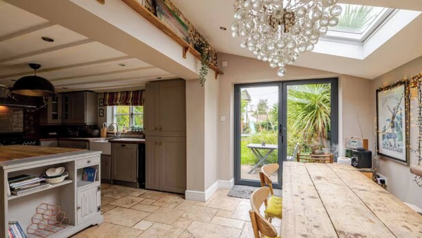 A spacious kitchen with a dining area, a chandelier, and a view of the outdoors. - Stone Cottage Norfolk , Lovely Family Cottage (Norwich)