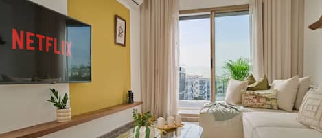 Appartement Deluxe | Coin séjour | TV connectée de 60 pouces avec chaßnes numériques, Netflix