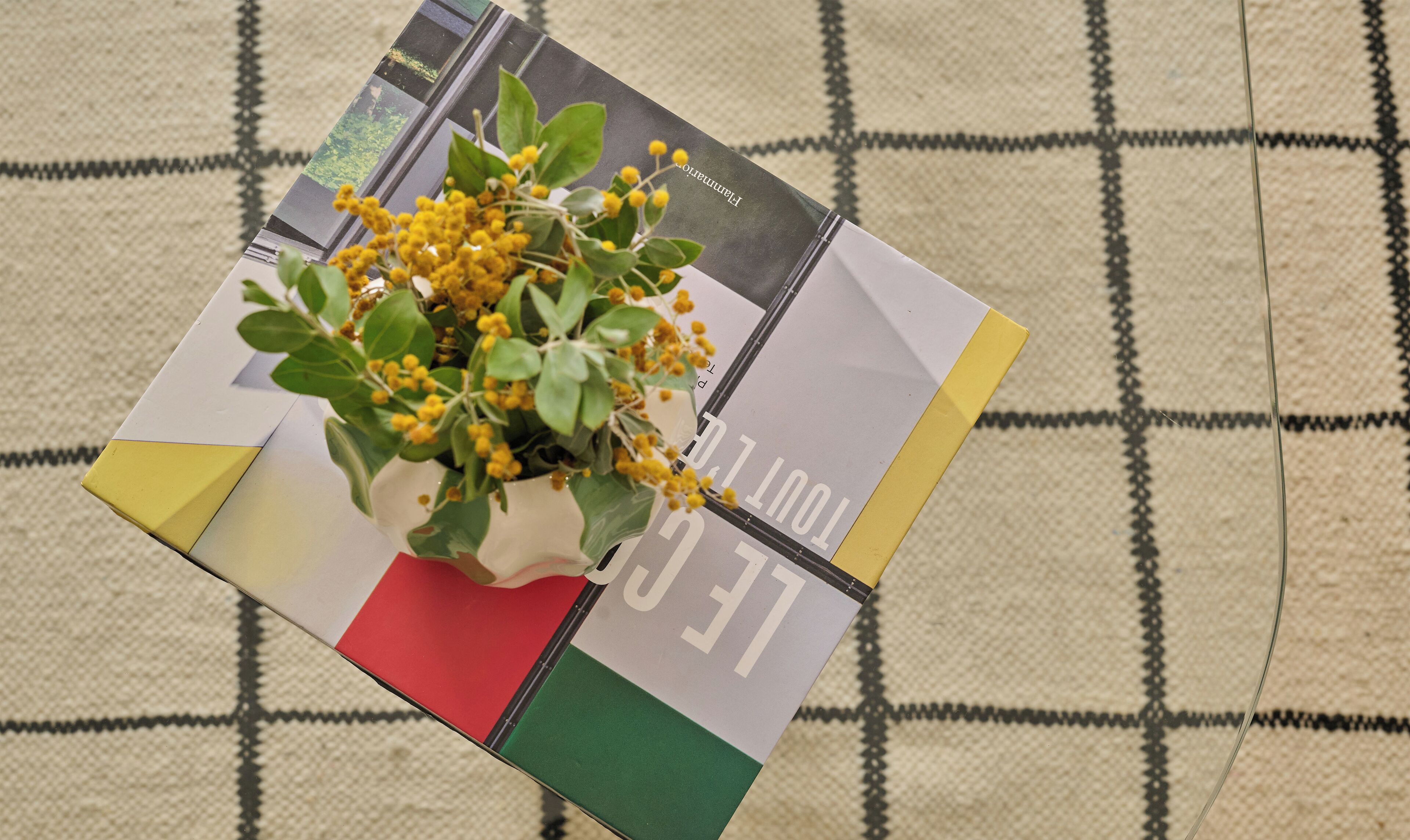 A CD or DVD with a yellow flower arrangement on top.