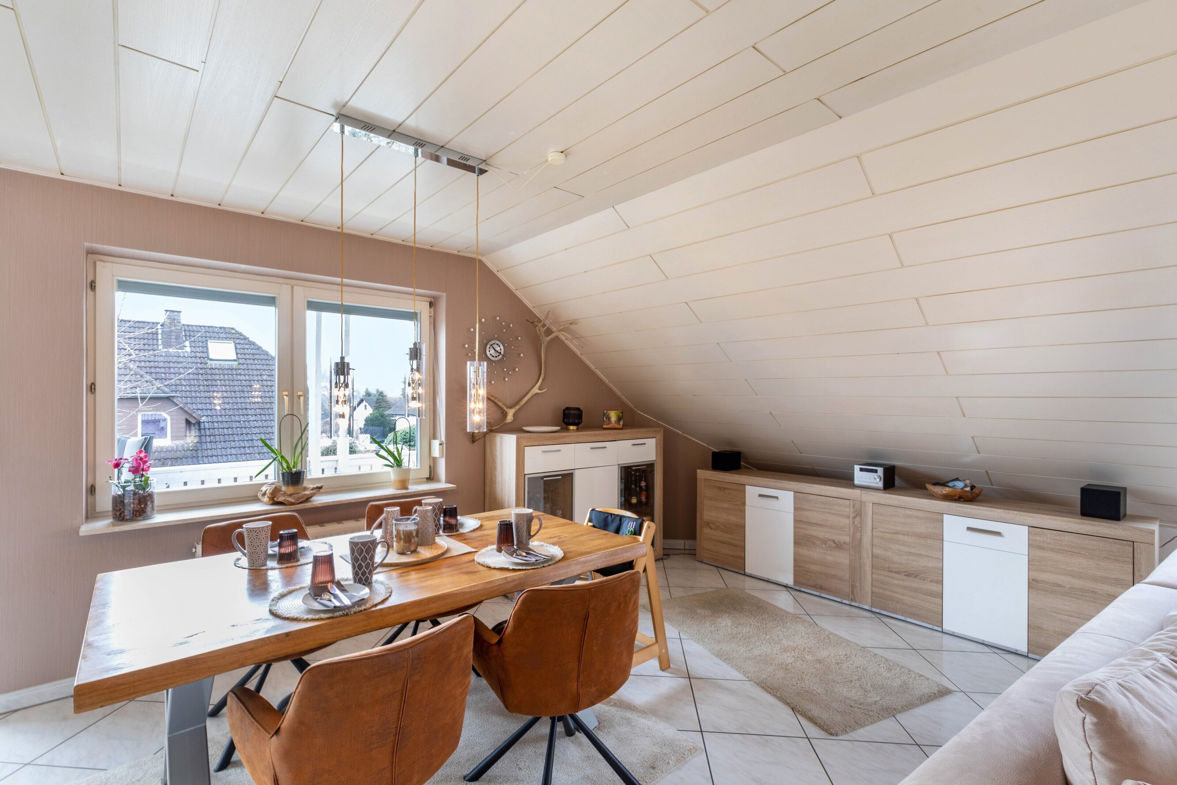 Una cocina moderna con comedor, un dormitorio en entrepiso y vistas al exterior.