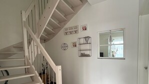 A staircase leading to a landing with a white wall, a welcome sign, and a window. - Apartment 'Repetal' with Private Terrace, Garden and Wi-Fi (Attendorn)