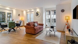 A modern living room with a sofa, dining area, and a large window. - Exclusive holiday flat - just a few steps from the lake (Überlingen)
