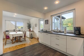 A modern kitchen with a dining area, large windows, and a view of the outdoors. - Apartment 'Rasche' with Balcony (Schmallenberg)