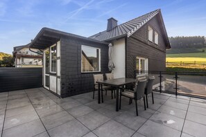 A two-story house with a balcony, a dining table, and chairs. - Apartment 'Rasche' with Balcony (Schmallenberg)