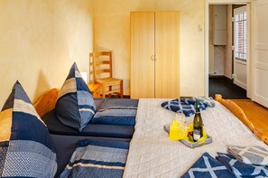 Ein Schlafzimmer mit einem Bett, einem Sessel, einem Kleiderschrank und einem Fenster.