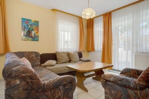 Un salon avec un canapé, une table basse et un tableau accroché au mur.