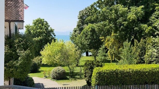 Ein Wohngebiet mit Blick auf das Meer, üppiger Bepflanzung und einem gepflasterten Weg.