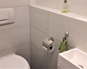 Ein Badezimmer mit Toilette, Waschbecken und Handtuchhalter.