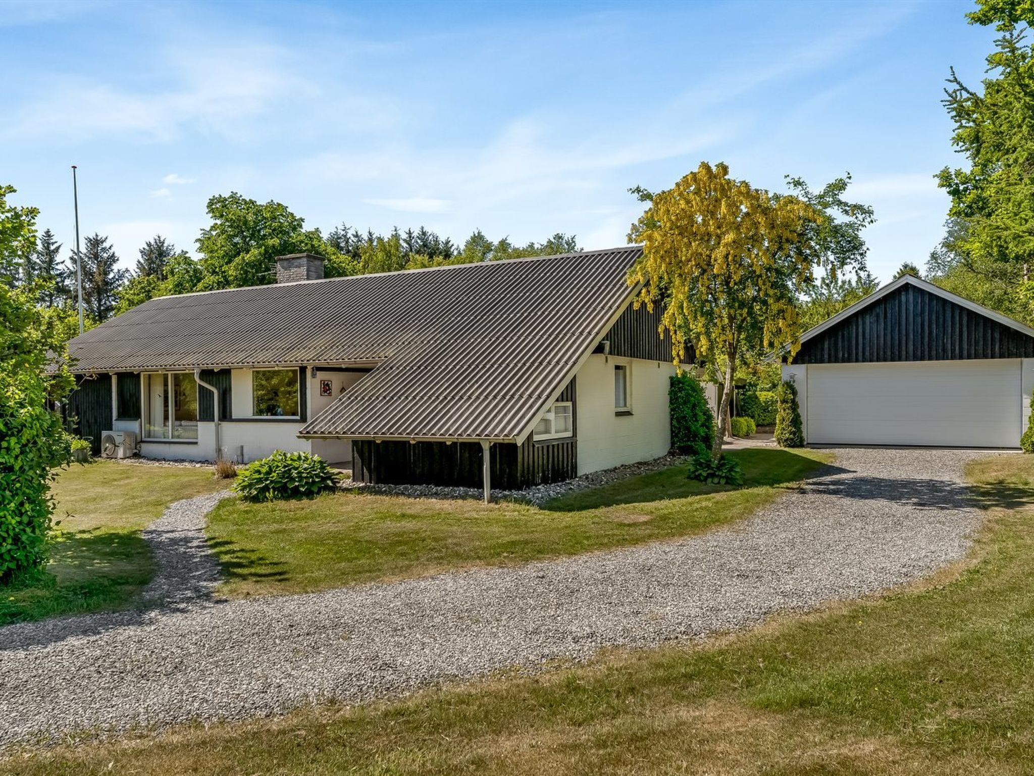 A two-story house with a sloped roof, a covered porch, and a garage.