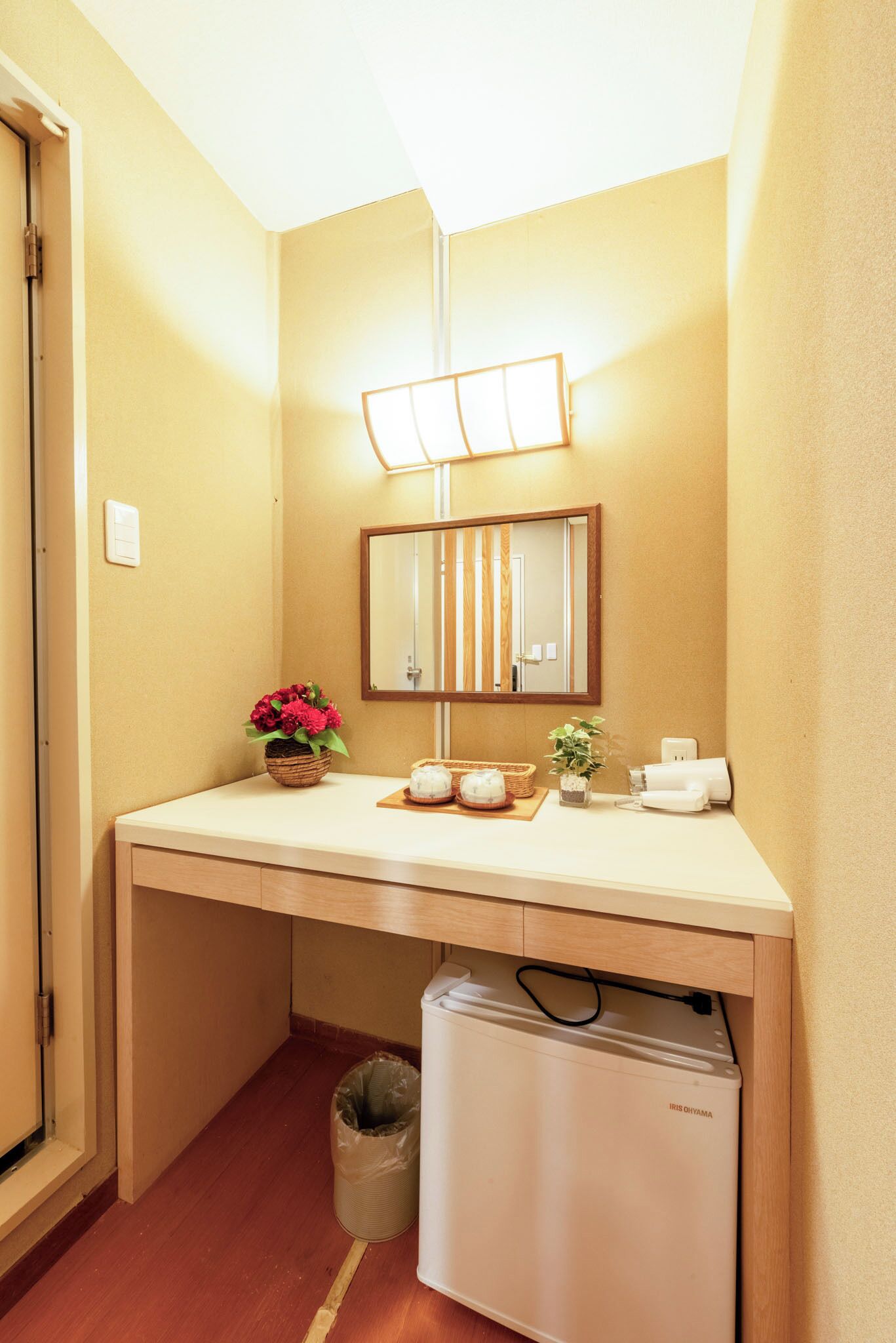 A compact bathroom with a sink, mirror, and a small trash bin.