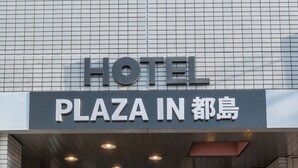 A hotel entrance with a sign reading "HOTEL PLAZA IN".