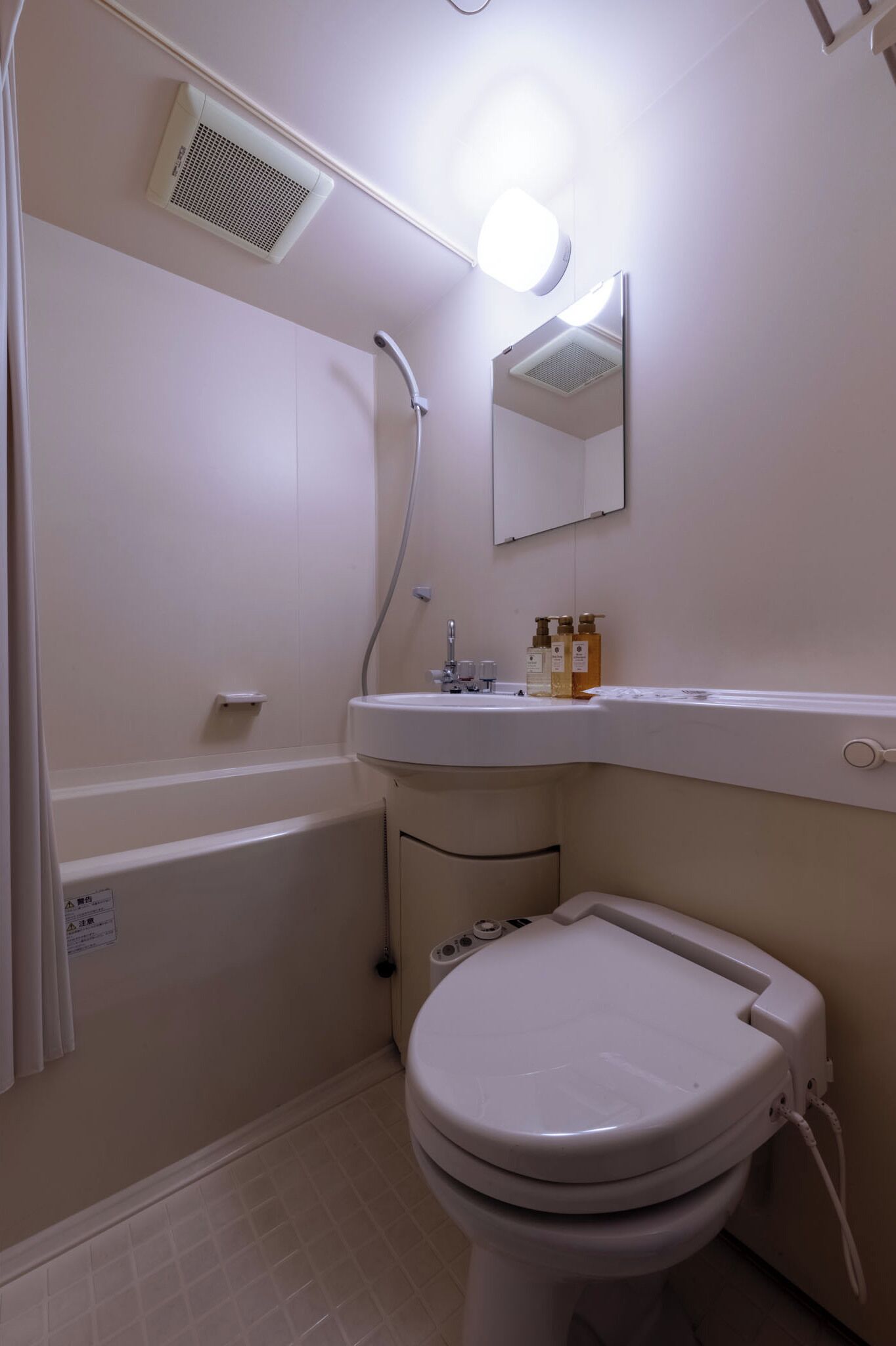 A bathroom with a bathtub, a toilet, a sink, and a mirror.