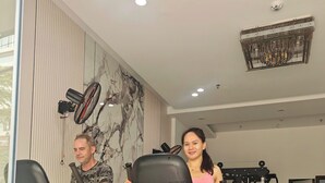 Une salle de sport équipée de tapis de course, d’un ventilateur fixé au mur et d’un appareil de climatisation installé au plafond.