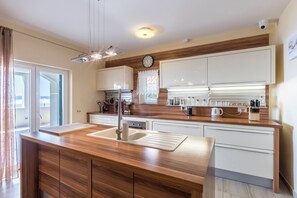 Enjoy cooking in this well-equipped kitchen with a central island, sink, and cutting board.