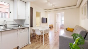 Un appartement moderne comprenant une cuisine, un coin repas et un salon.