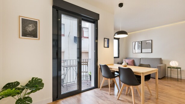 Un appartement moderne comprenant un coin repas, un canapé et un balcon.