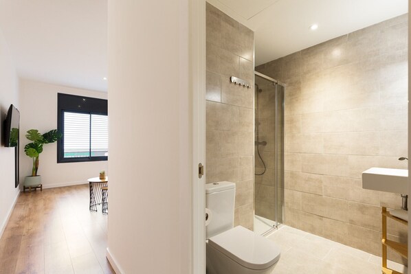 Un baño moderno con ducha, inodoro y lavamanos.