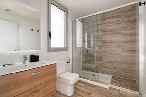 Exclusief appartement | Badkamer | Een douche, een haardroger, handdoeken, zeep