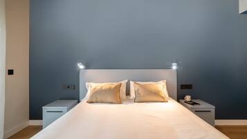 A bedroom with a bed, two bedside tables, and a nightstand.