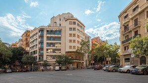 A multi-story building with a modern architectural style, featuring balconies and large windows.