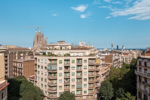 A high-rise building with multiple balconies and a construction crane in the background. - Sagrada Familia Apartment By Olala Homes (Barcelona)