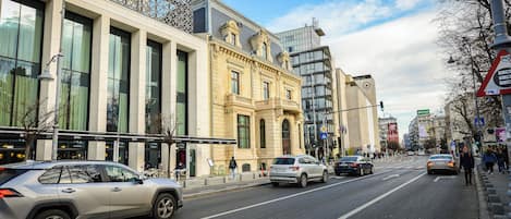 A street with cars, pedestrians, and buildings.