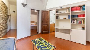 A room with a bed, a wooden door, a bookshelf, and a tiled floor. - GuestHost - Comfortable apartment of approximately 50 square meters, able to accommodate up to 4 people, located on the ground floor of an ancient building, but in good condition. The apartment is located in the Porta Romana-Boboli district (Traffic-Rest (Firenze)