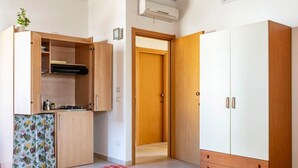 Une chambre dotée d’une kitchenette, d’une armoire et d’un tapis à motifs.