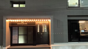 A building entrance with a sign reading "THE DOUZA BLDG." - Capsule Hotel Nagasaki (Nagasaki)