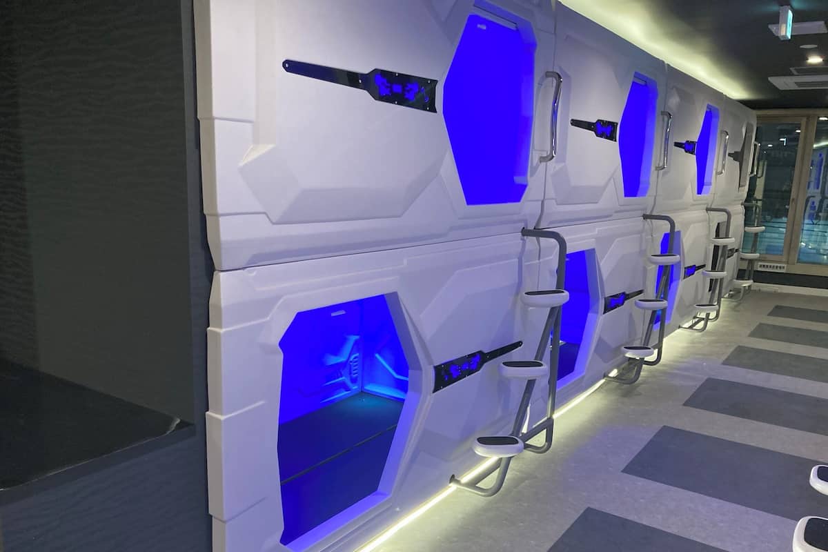 Une rangée de modules blancs, au design futuriste, agrémentés d’éclairage bleu et de poignées métalliques.