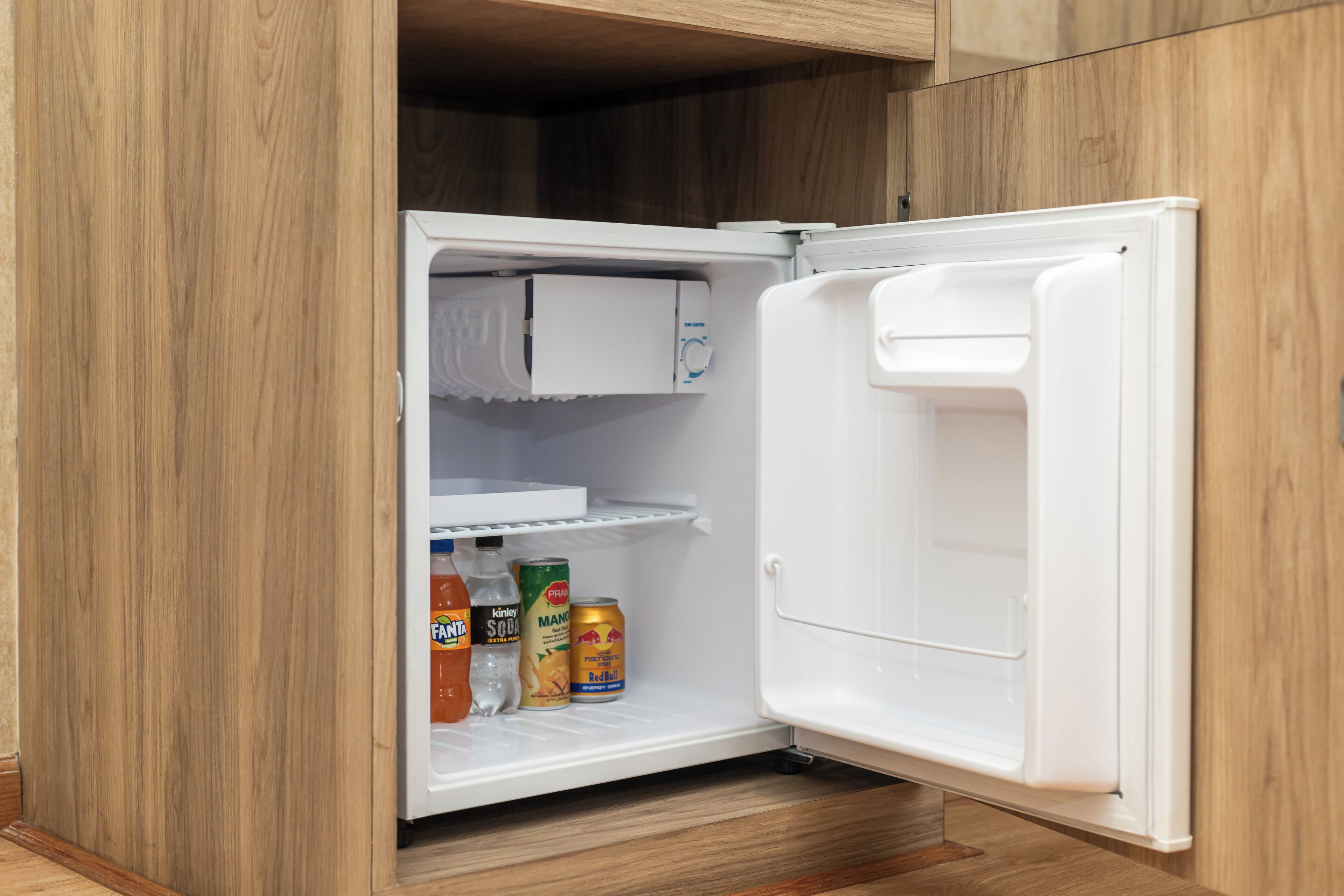 Ein offener Kühlschrank mit Getränken auf einer Ablage und einer Eierkarton.