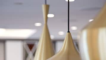 A modern interior with pendant lighting and a long table with floral centerpieces.